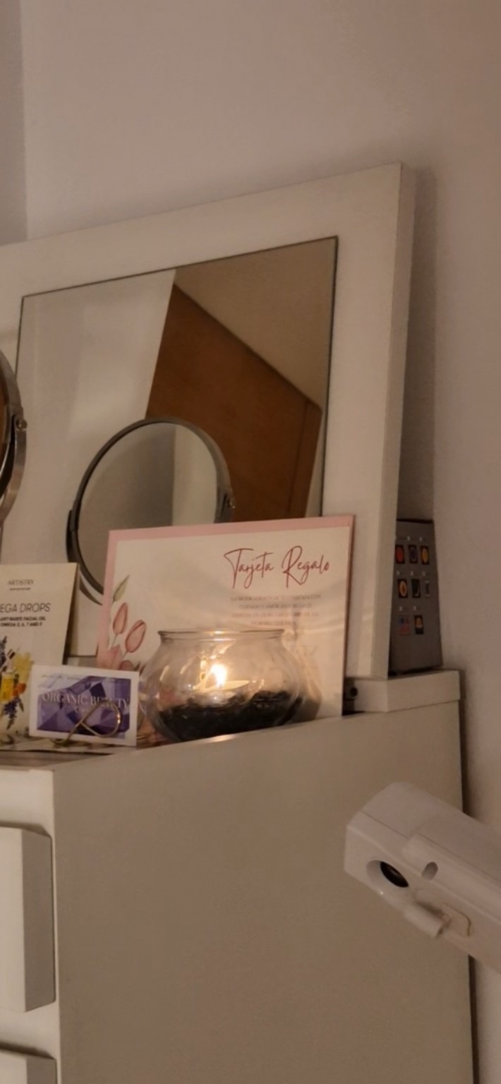 Tarjeta regalo de OBC junto a una vela en la sala